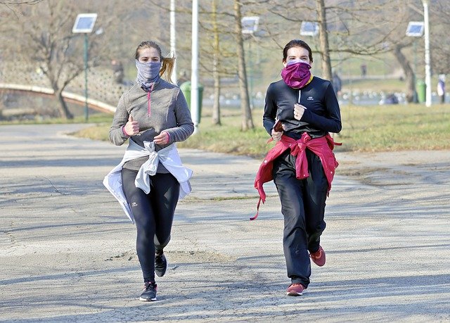 Two women running with masks on