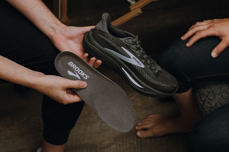 A Brooks running shoe with the original insert pulled out
